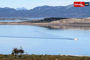 13:31 hs. Un barco traza su estela en la plácida Bahía Ushuaia