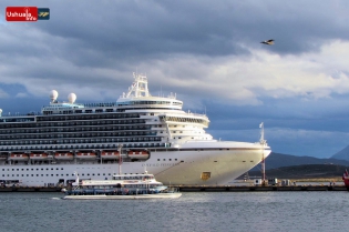 19:23 hs. Un catamarán regresa a puerto frente al crucero Emerald Princess